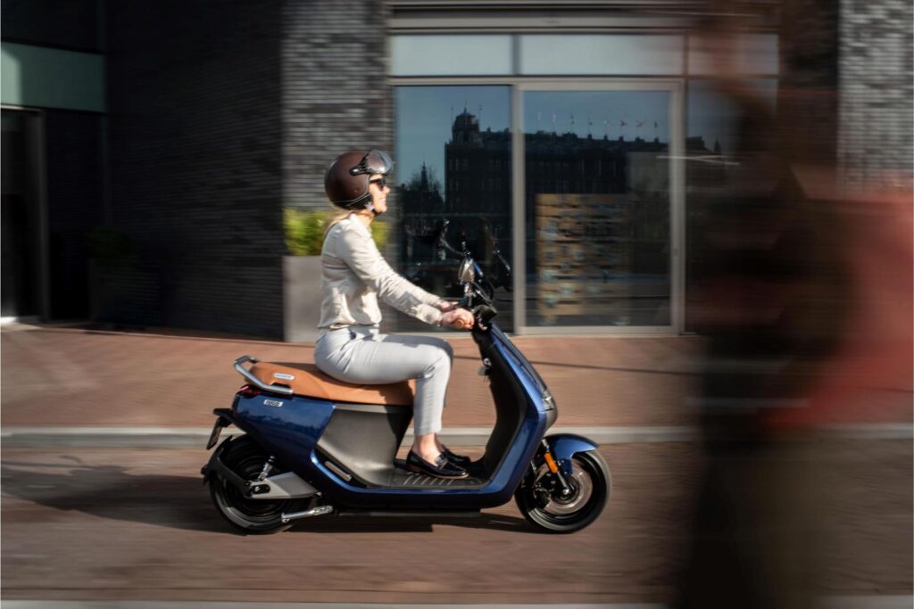 Segway e-Scooter E125S Lifestyle Girl riding in motion side view